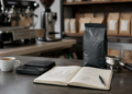 Filiżanka espresso, waga baristyczna i notes z analizą kosztów kawy w kawiarni